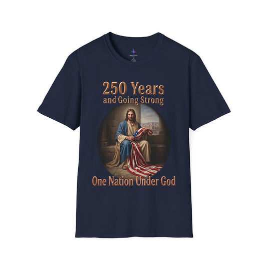 Navy blue t-shirt with graphic artwork featuring a classical-style painting of Jesus Christ sitting on stone steps, holding and draping a large American flag. The circular portrait is set against a solid background, with the metallic gold text "250 Years and Going Strong" printed across the top, and the phrase "One Nation Under God" written in a matching bold gold font along the bottom.